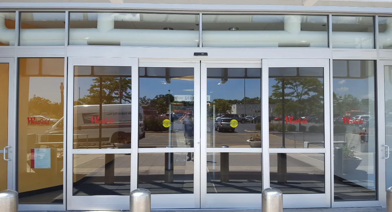 Automatic door operator installed on commercial entry door with push-button activation for wheelchair access